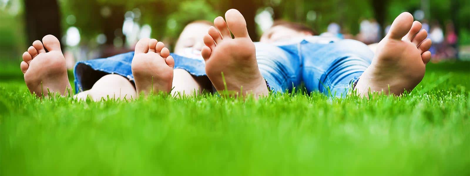 feet on grass. Family picnic in spring park