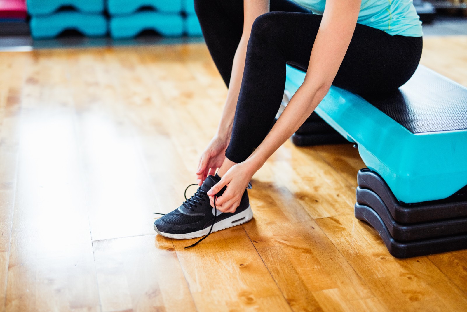 woman tying her shoes before starting a workout