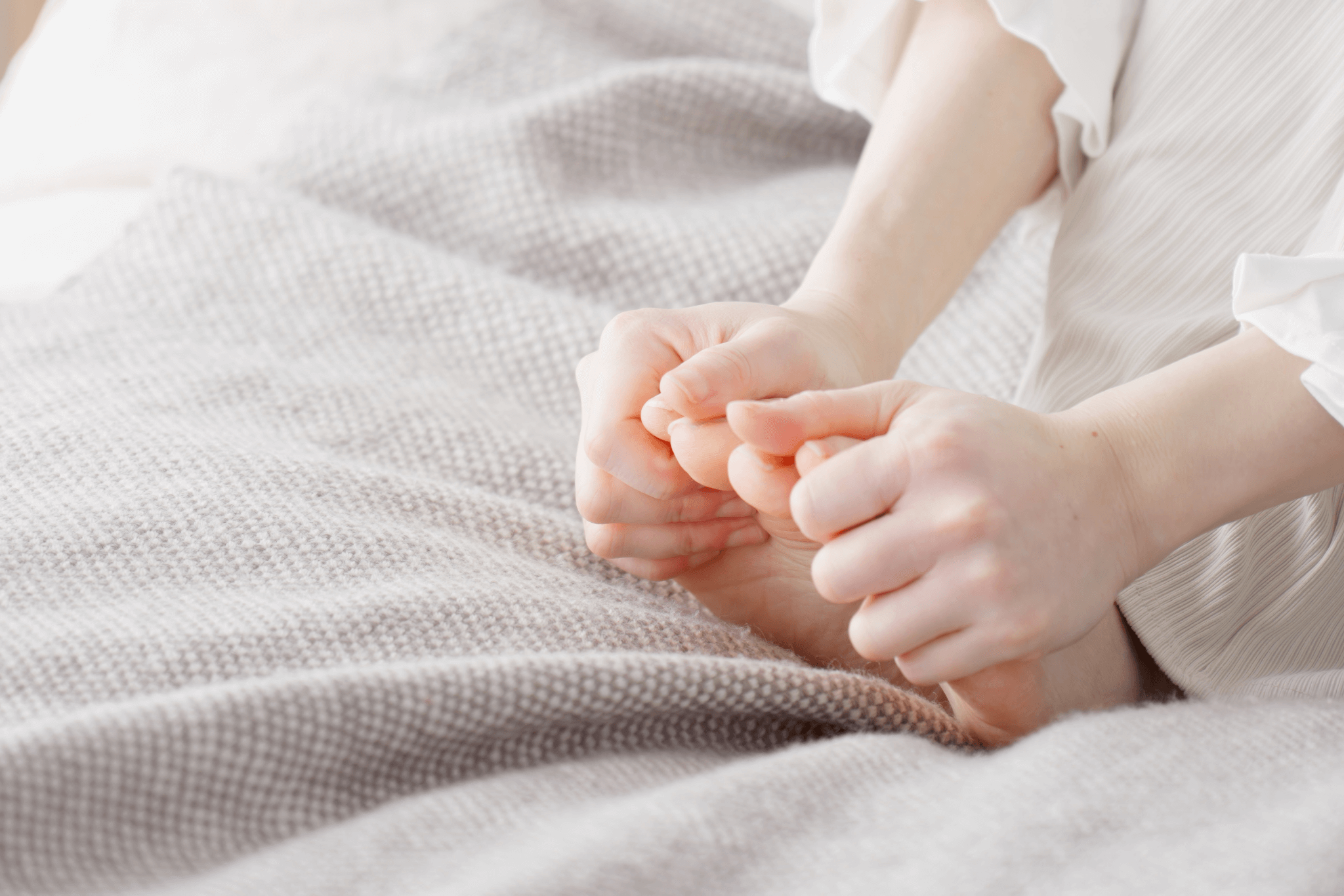 woman sitting holding her toes